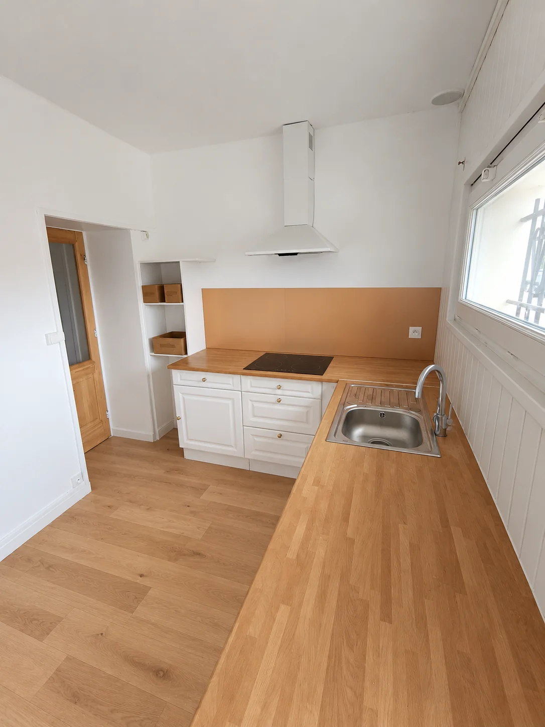 Cuisine rénovée avec crédence beige et plan de travail en bois