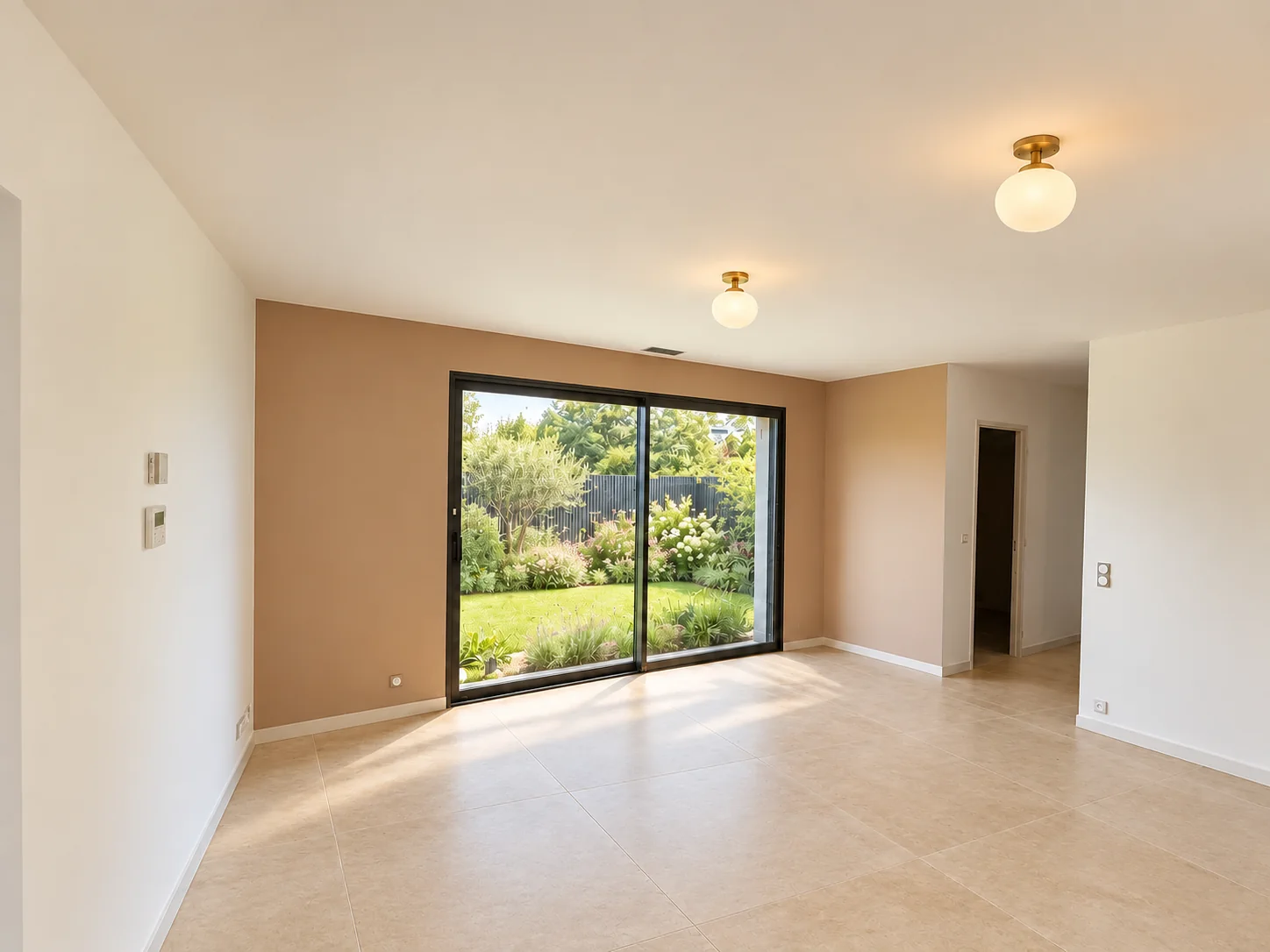 Séjour lumineux avec mur beige, baie vitrée et sol carrelé